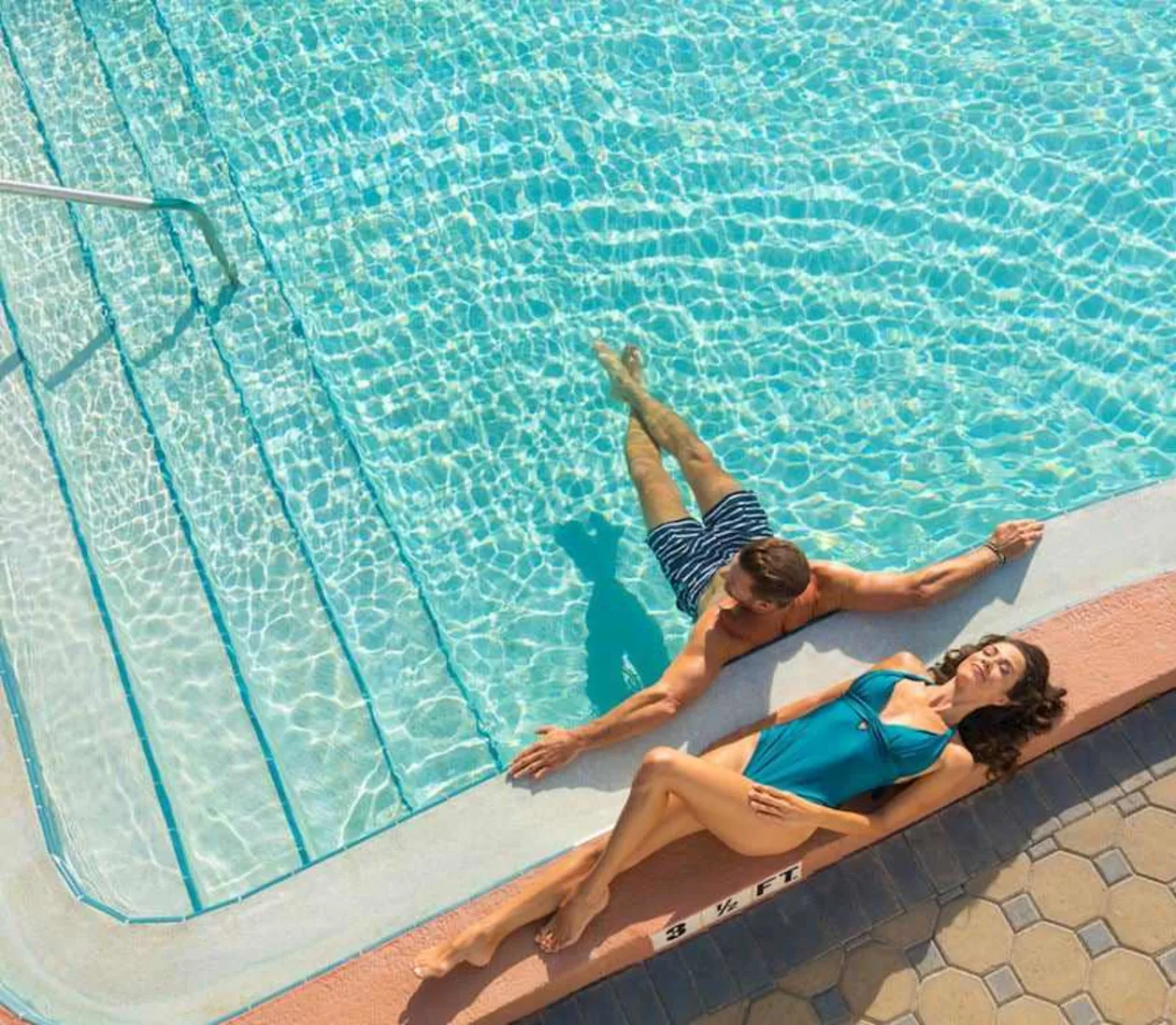 Couple at pool using resort day pass at The Don CeSar